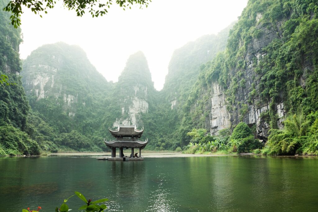Vietnam travel costs 2026 — misty karst mountains and pagoda in Ninh Binh | tripbudgetcalculator.com